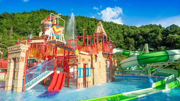 A water park with a large water slide, a water jet, and a pool.