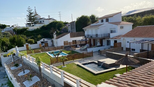 A residential area with a swimming pool, a hot tub, and a patio with outdoor furniture.