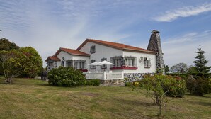 A large white house with a red roof, a stone chimney, and a white picket fence. - Finca Engracia Tranquilidad, Comodidad y Descanso (Cudillero)