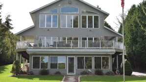 Une maison à deux étages dotée d’un balcon, de grandes fenêtres et d’un mât pour drapeau.