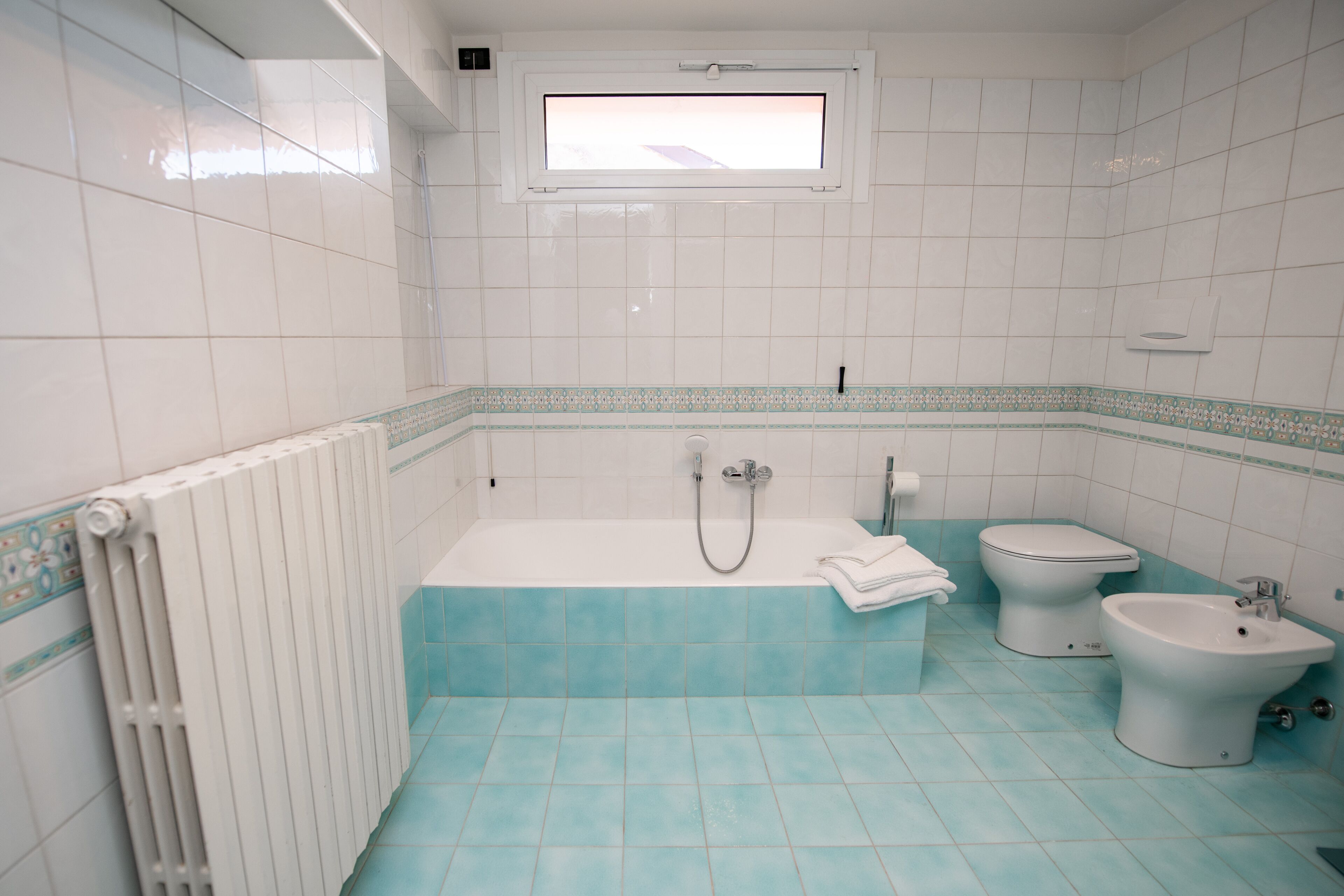 Ein Badezimmer mit Badewanne, zwei Toiletten und einem Bidet.