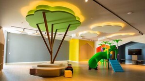 A modern interior with a play area, including a slide and climbing structures.