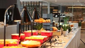 A buffet setup with various food items and a modern interior design.
