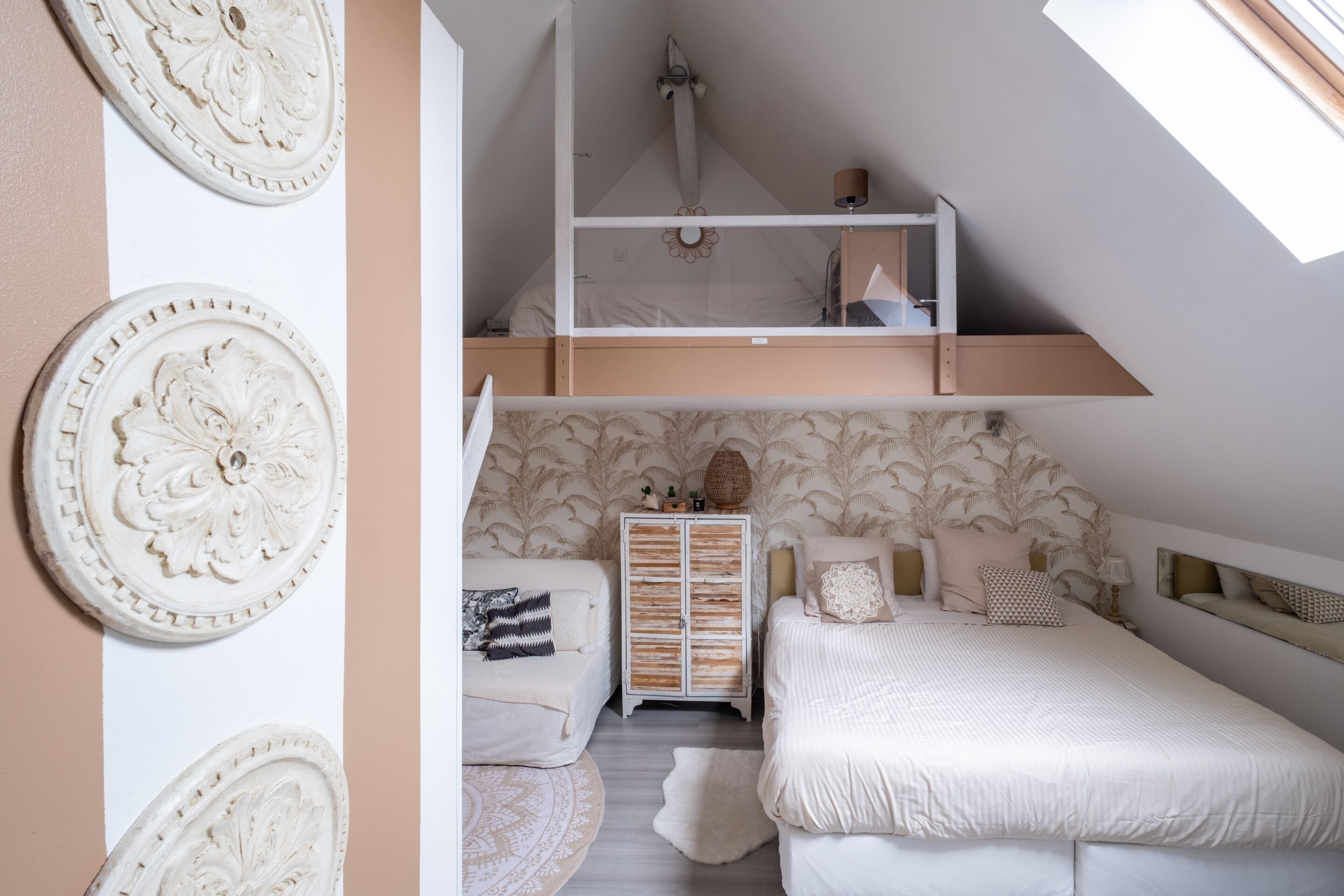 A bedroom with a loft bed, a chest of drawers, and decorative wall art.