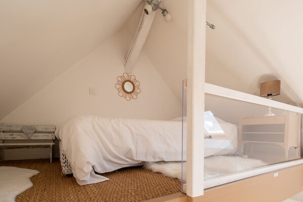 A bedroom with a bunk bed, a small desk, a mirror, and a decorative wall hanging. - Le Clos Saint Paul (Vexin-sur-Epte)