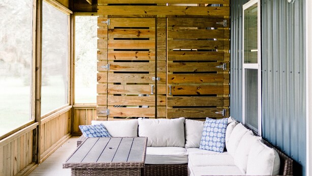 A covered porch with a wooden ceiling, wicker furniture, and a view of the outdoors. - Downstairs Studio style apartment on the River (Mermentau)