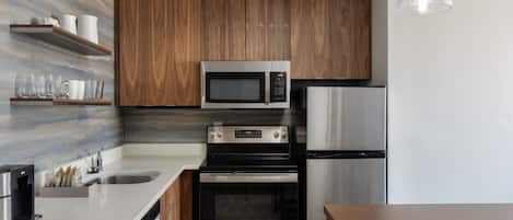 Una cocina moderna con armarios de madera, electrodomésticos de acero inoxidable y salpicadero de mármol.