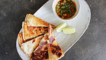 Un plato de quesadillas y un tazón de salsa.