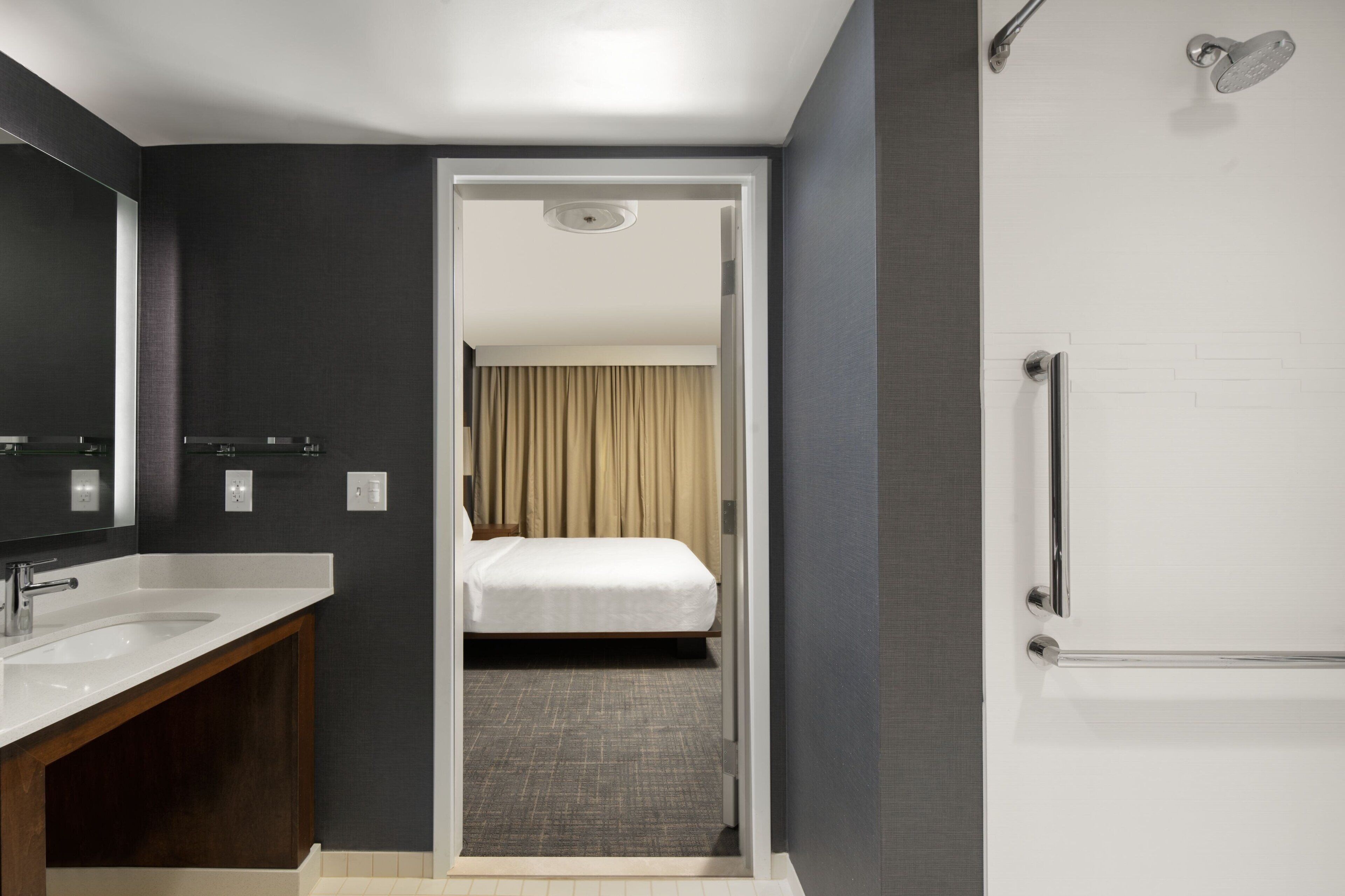 Una habitación de hotel moderna con baño, cama y ducha.