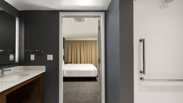 Una habitación de hotel moderna con baño, cama y ducha.