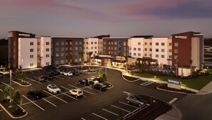 A multi-story hotel with a parking lot, a swimming pool, and a landscaped area. - Residence Inn by Marriott Tampa Wesley Chapel (Wesley Chapel)