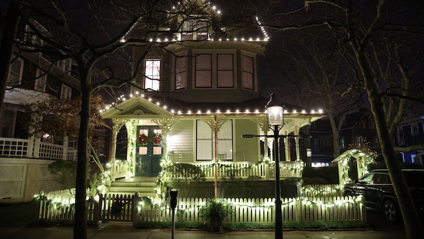 A house with a porch decorated with string lights and a white picket fence. - Beautifully Renovated in Heart of Cape May - 1 Block to Beach; 1 Block to Mall (Cape May)