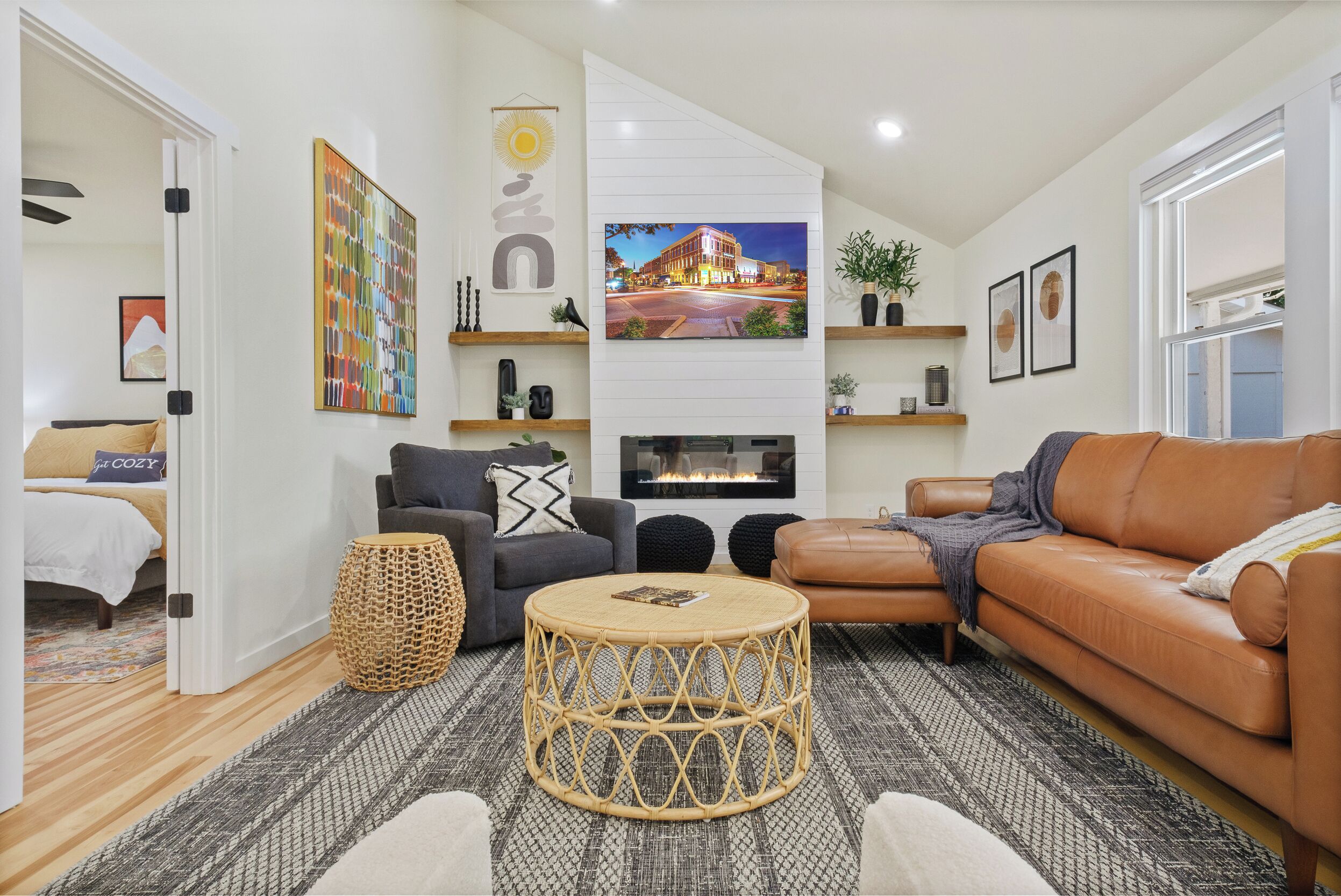 A modern living room with a fireplace, comfortable seating, and a large TV.