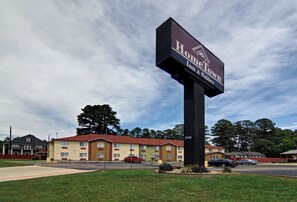 A hotel sign with 'HomeTown Inn & Suites' branding, a parking lot, and a building with a red roof.