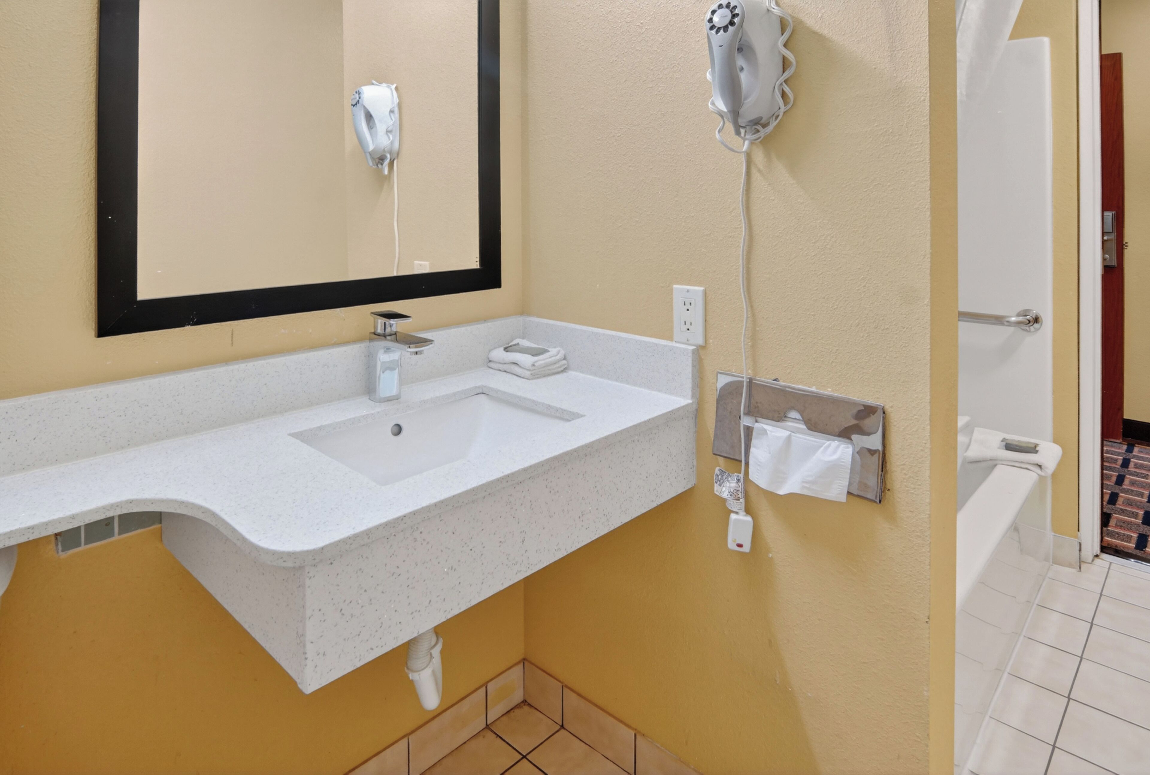 A bathroom with a white sink, mirror, and towel rack.