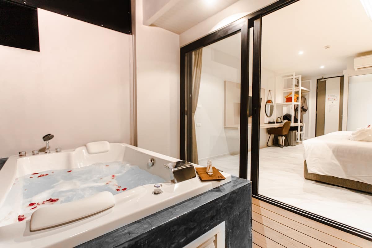 A modern bathroom with a large bathtub, a vanity, and a mirror.