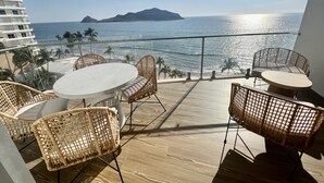 A balcony with wicker furniture, a view of the ocean, and a distant mountain. - Increible depa con vista al mar. Z.dorada(factura) (Mazatlán)