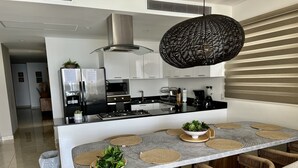 A modern kitchen with a central island, stainless steel appliances, and a hanging light fixture. - Increible depa con vista al mar. Z.dorada(factura) (Mazatlán)