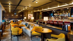 A bar area with seating and a bar counter. - Hotel Indy, Indianapolis, a Tribute Portfolio Hotel (Indianapolis)