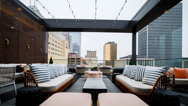 A rooftop lounge with seating areas, a view of the cityscape, and a modern architectural design. - Hotel Indy, Indianapolis, a Tribute Portfolio Hotel (Indianapolis)
