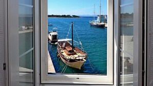 A view from a room with a large window overlooking a marina with several boats docked. - A2 - Cozy Apartment, Best Location in Supetar (Supetar)
