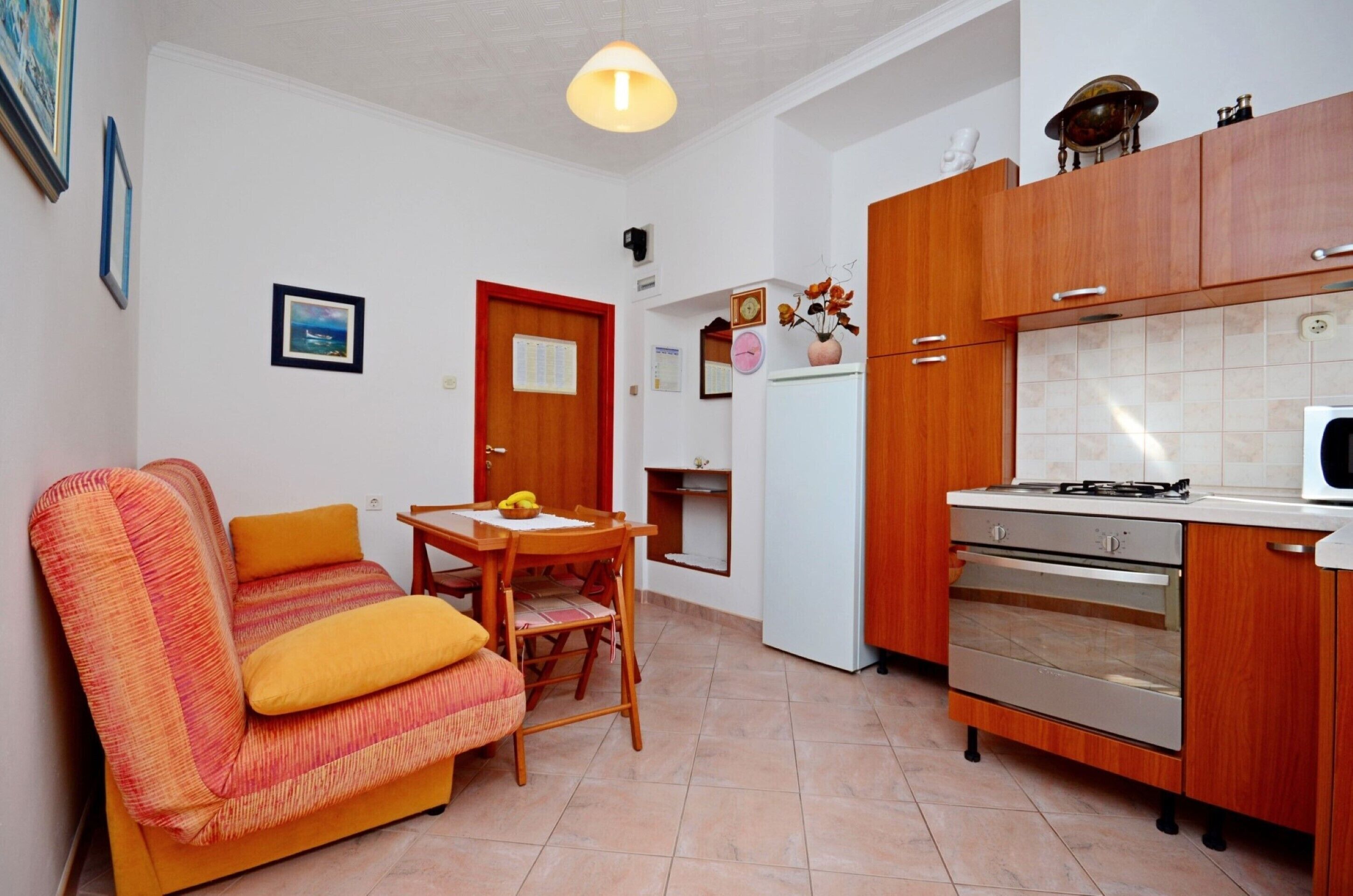 A compact living space with a sofa, dining table, and kitchenette.