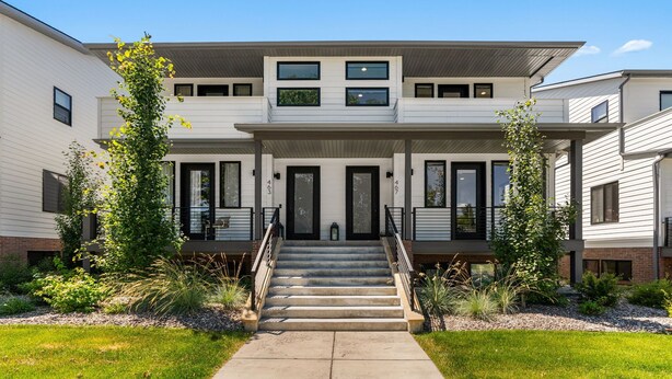 A two-story residential building with a central entrance, a staircase, and a small garden area.