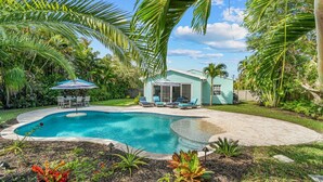 A backyard with a swimming pool, a covered patio, and a small house. - Swim Up Bar - Outdoor Paradise! (Delray Beach)