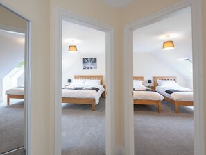A bedroom with two wooden beds, a ceiling light, and a wall-mounted artwork. - Dawson Park 7 - UK12666 (Mablethorpe)