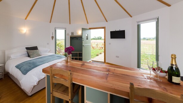Un dormitorio con cama, mesita de noche y vistas al exterior.