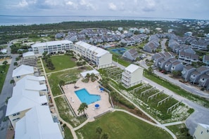 An aerial view of a residential area with multiple houses, a swimming pool, and a tennis court. - Sea Cliffs rental with elevator SUN-SUN Rental (Port Saint Joe)