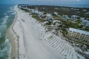 An aerial view of a coastal area with a sandy beach, beachfront properties, and a large building with multiple floors. - Sea Cliffs rental with elevator SUN-SUN Rental (Port Saint Joe)