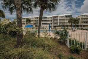 A multi-story hotel with balconies, a swimming pool, and palm trees. - Sea Cliffs rental with elevator SUN-SUN Rental (Port Saint Joe)