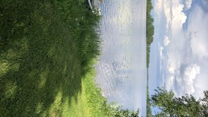 A boat docked at a calm lake surrounded by lush greenery.