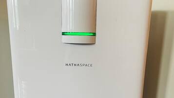 Ein weißer, moderner Kühlschrank mit grüner Leuchte und dem Schriftzug "HATHASPACE" vorne.