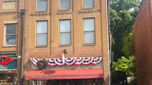 A brick building with a red awning and a sign that reads "Antiques & Artisans."