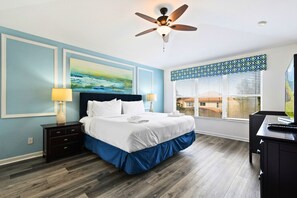 Relax in comfort with a large bed, bedside tables, and a ceiling fan.