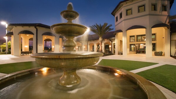 A fountain in a courtyard with a building in the background.