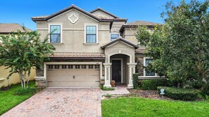 A two-story house with a garage, a brick driveway, and a well-maintained lawn. - Spacious Champions Gate Home for Family Getaways (Davenport)