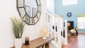 A staircase with a white railing leading to a living area.