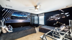 A room with a bed, a desk, a chair, a ceiling fan, and a wall mural. - Star Wars & Princess /w Pool, Game Rm Near Disney (Kissimmee)