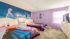 A bedroom with two beds, a nightstand, a dresser, and a TV.