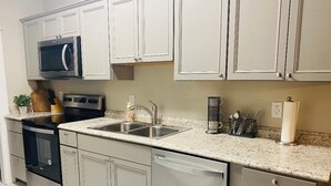 A modern kitchen with stainless steel appliances, a double sink, and light-colored cabinetry. - Amazing 1 Bedroom Apartment, Downtown Jonesborough (Jonesborough)