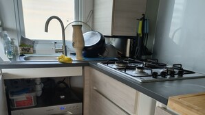 A modern kitchen with a built-in dishwasher, a stove, and a sink.