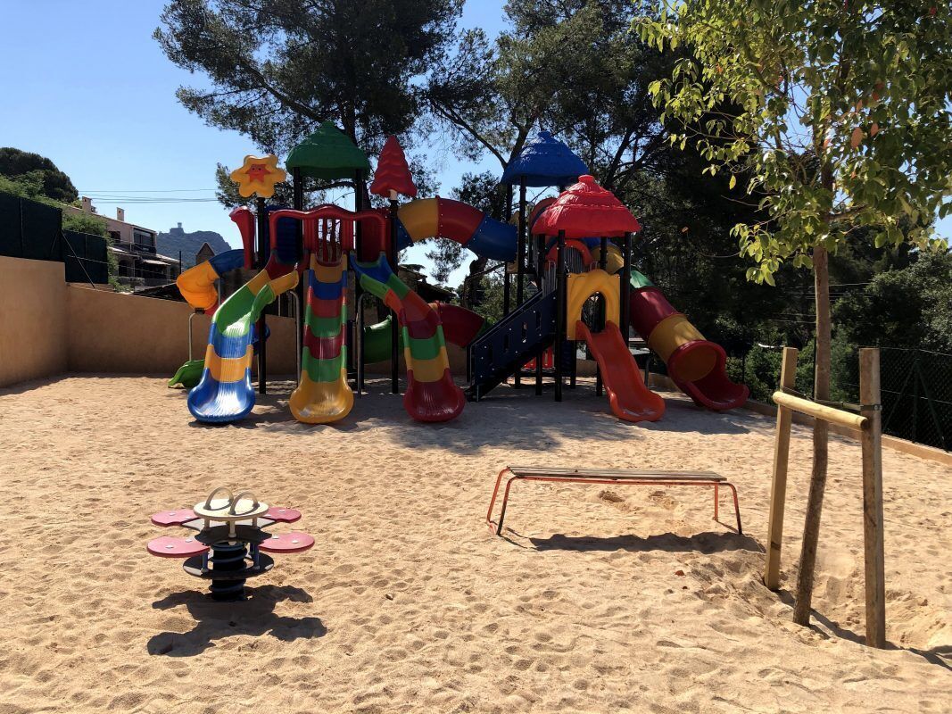A playground with colorful slides and a seesaw.