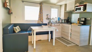 A compact kitchen with a dining area, a microwave, and a coffee maker.