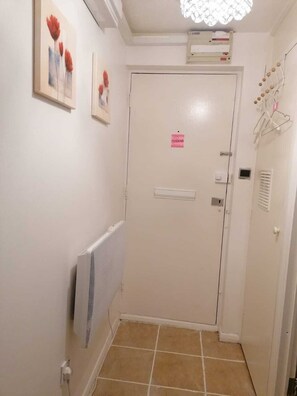 Comfortable hallway with a door, radiator, air conditioning unit, and framed artworks.