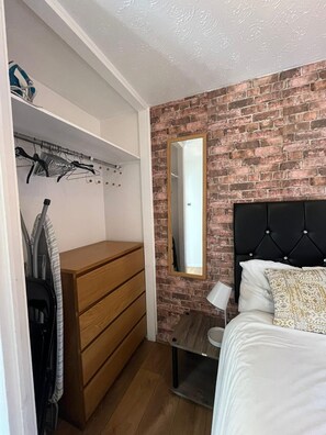 Cozy retreat with a single bed, bedside table, and dresser.