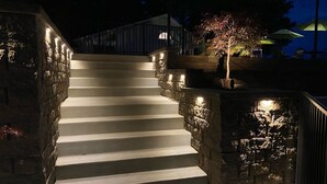 Un escalier avec des murs en pierre et un éclairage le long des marches.