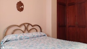 Une chambre à coucher avec un lit, une armoire en bois et un élément décoratif fixé au mur.